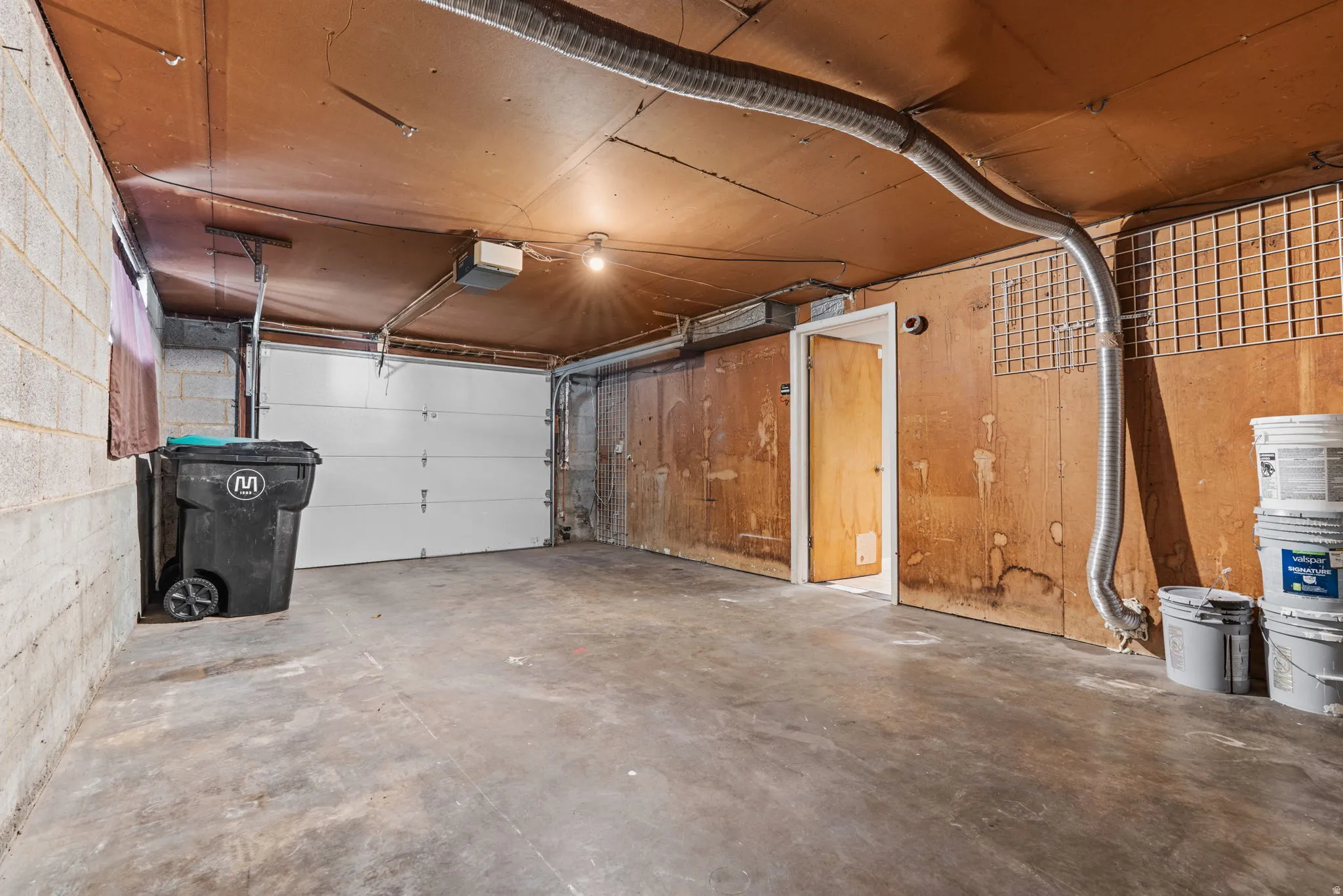 Concrete floor garage, featuring an insulated garage door, and door to interior.