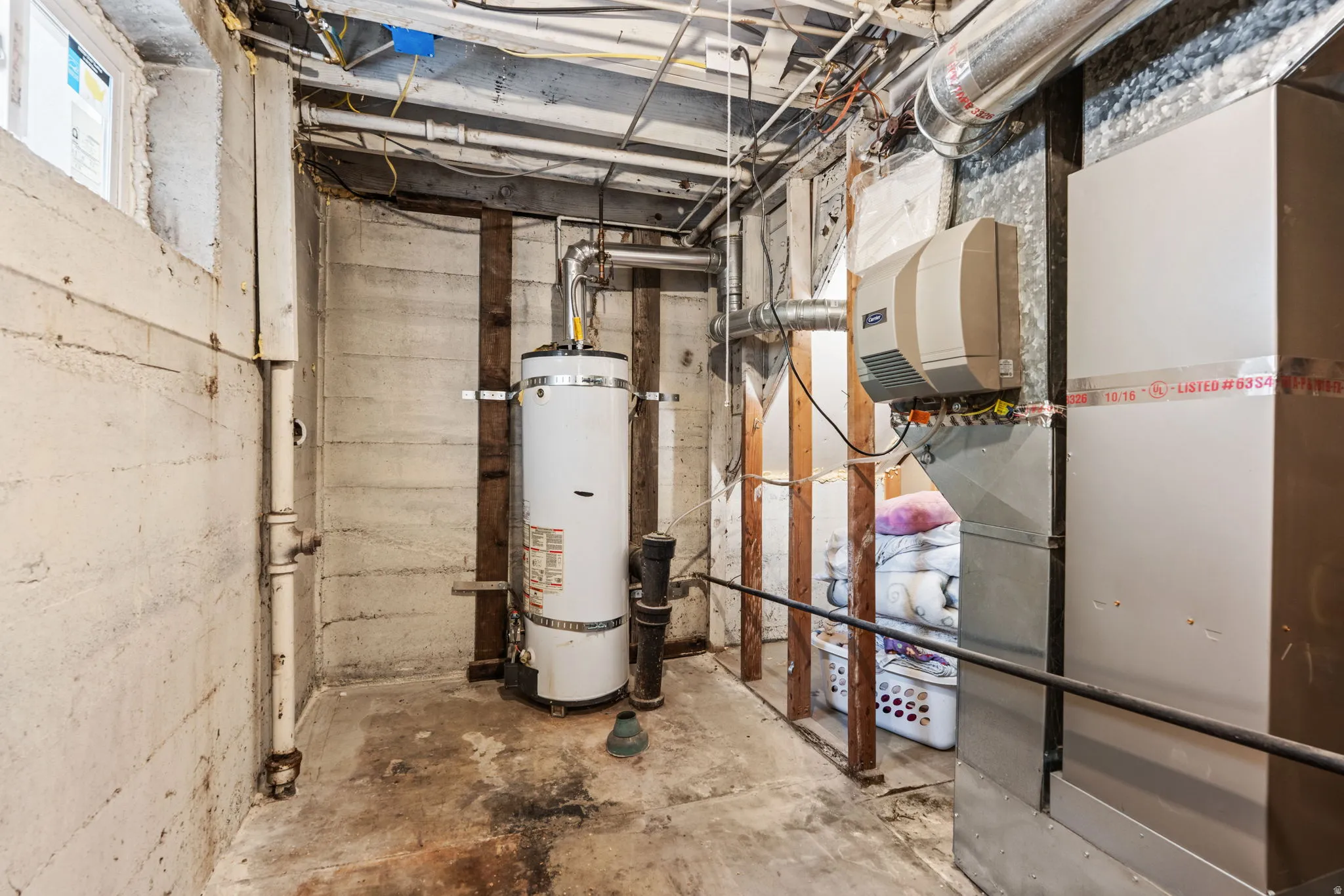 Utility area featuring a water heater, furnace, and ductwork