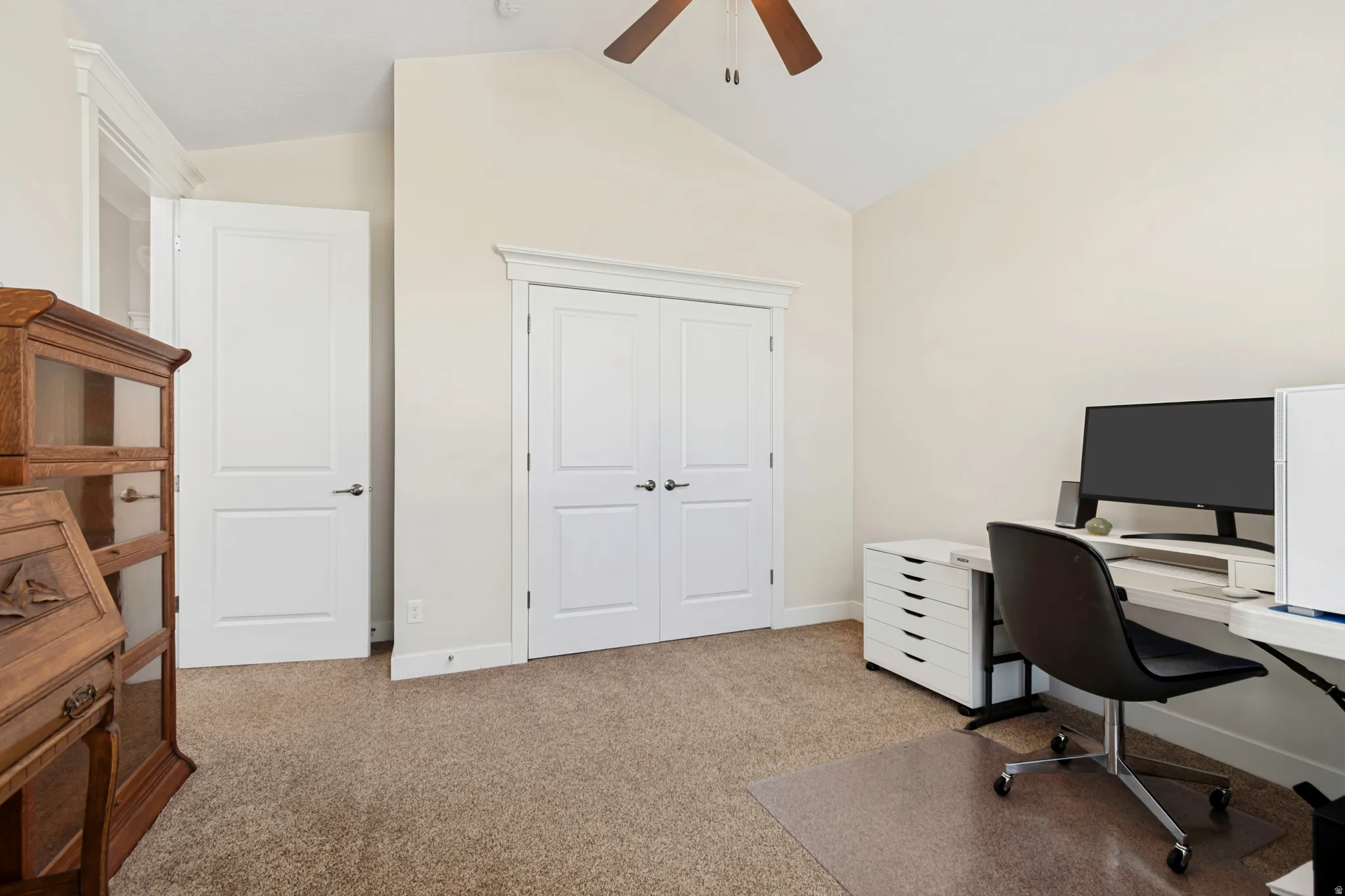 Room featuring vaulted ceilings and neutral-toned carpeting