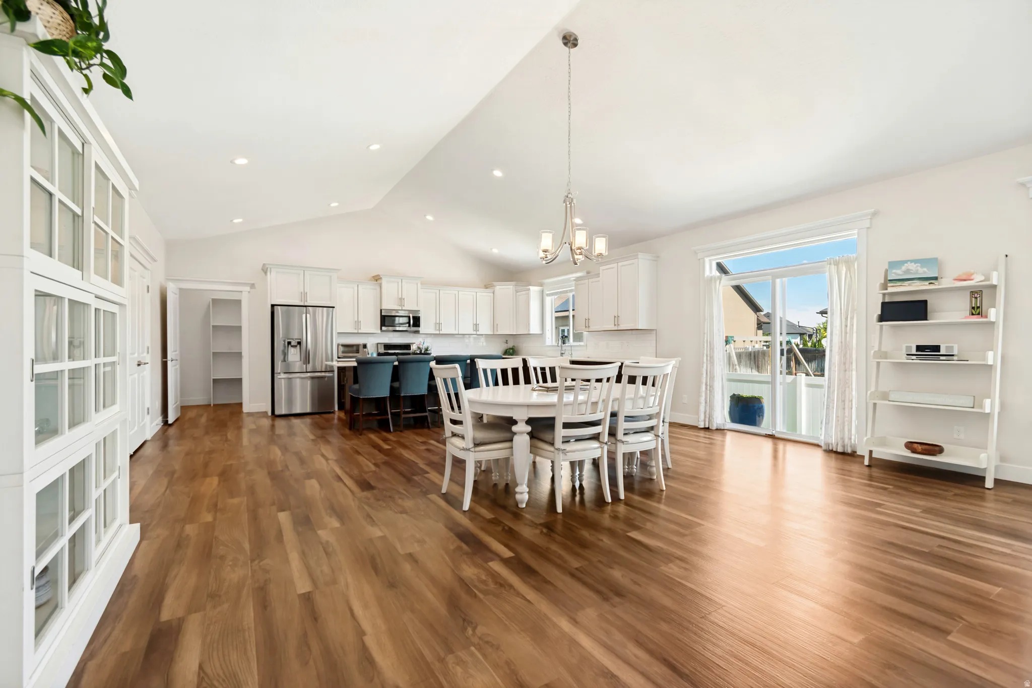 Bright open-concept living area featuring wood-finish flooring, vaulted ceilings, and recessed lighting