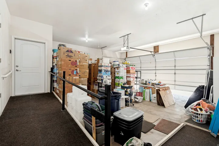 Spacious garage featuring a concrete floor, overhead lighting, and an automatic overhead door mechanism