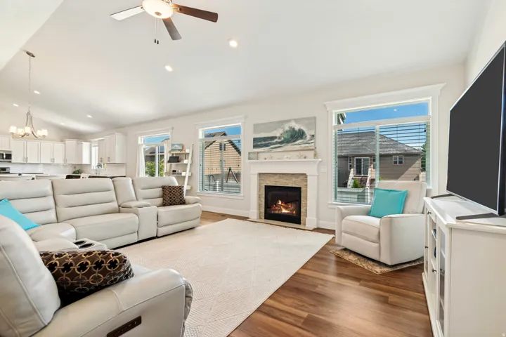 Open-concept living space featuring wood-finish flooring and a vaulted ceiling