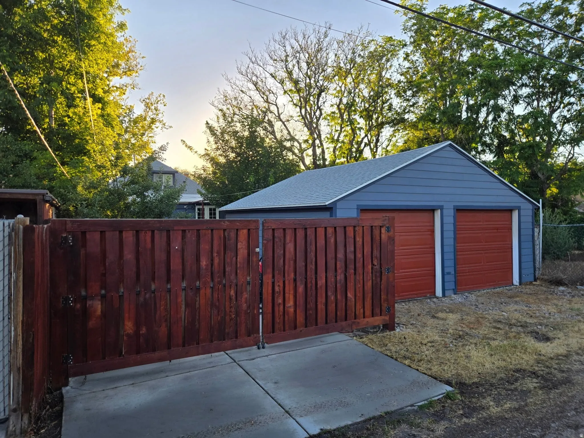 Detached two-car garage with blue siding and two orange garage doors