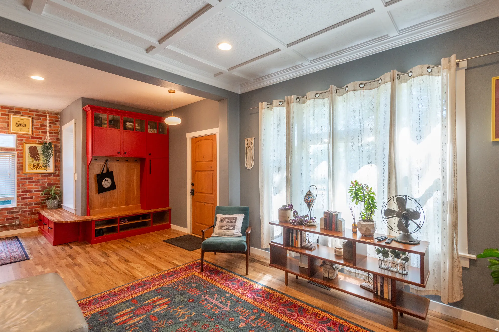 Open-concept living area with coffered ceilings and wood-finish flooring