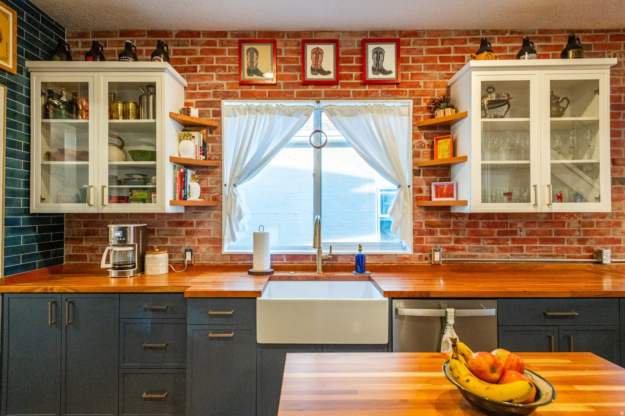 Kitchen featuring a brick-finish backsplash, wood-finish countertops, and a white apron-front sink