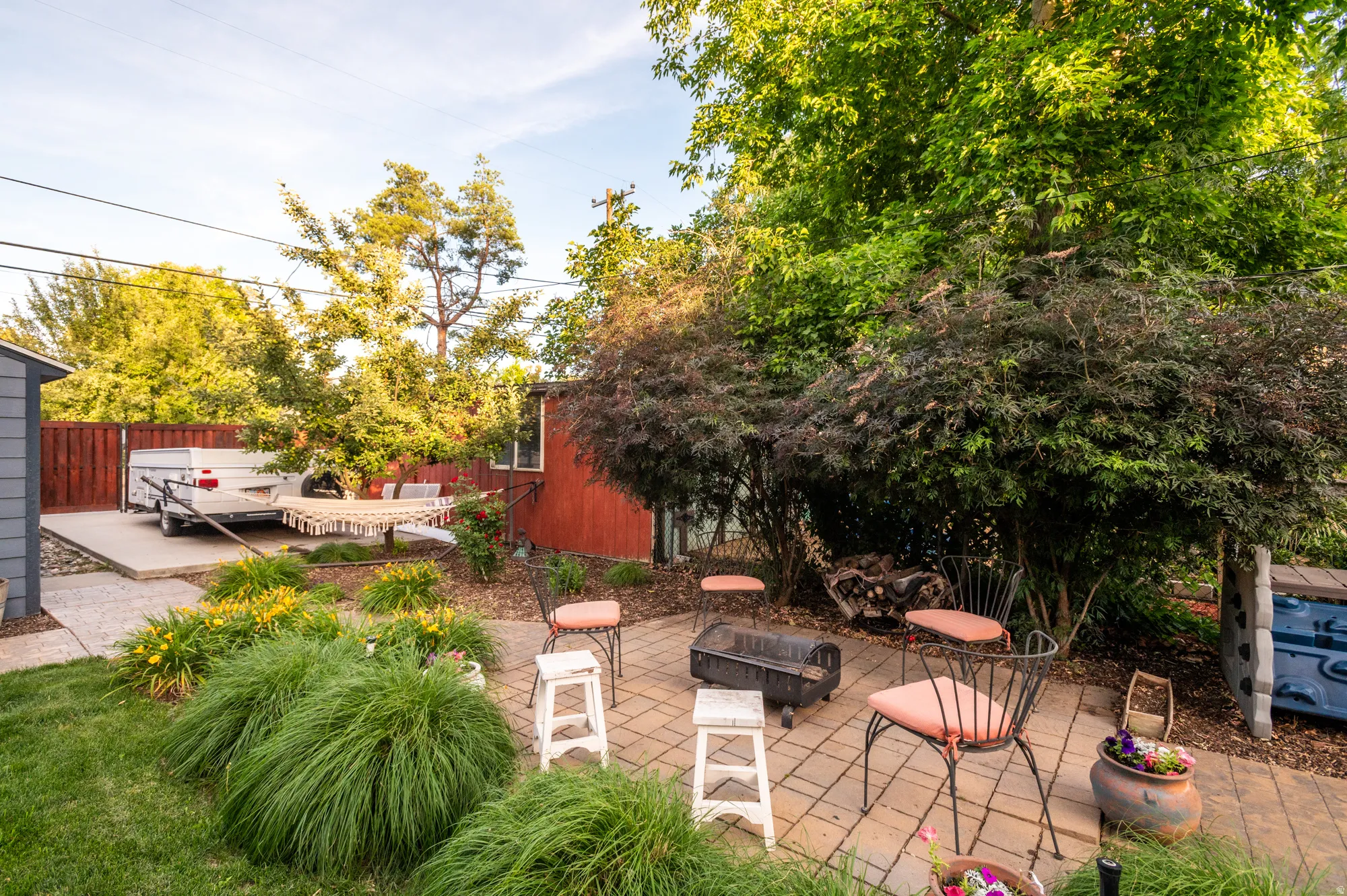 Paved patio area featuring lush landscaping and mature trees