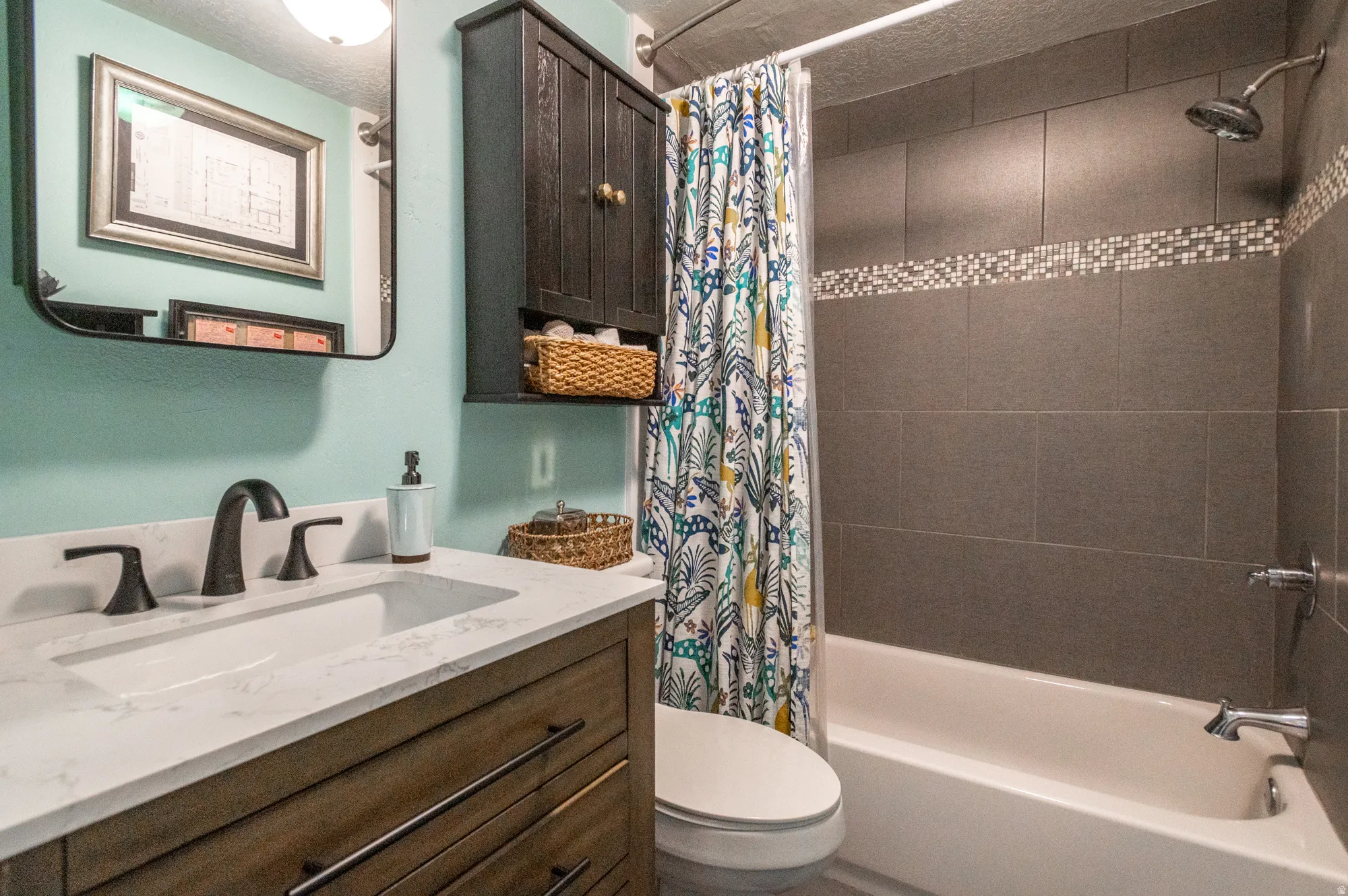 Bathroom featuring a wood-finish vanity with a white countertop and integrated sink