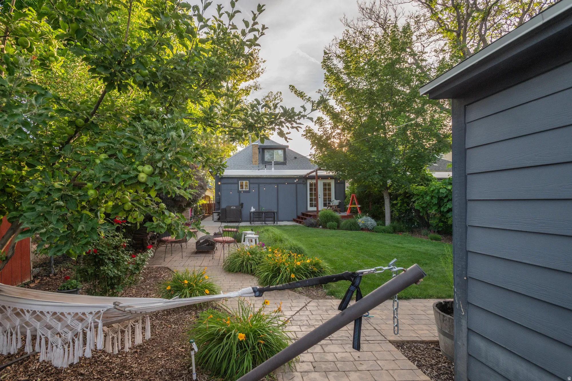 Manicured backyard with a paver patio and lush lawn