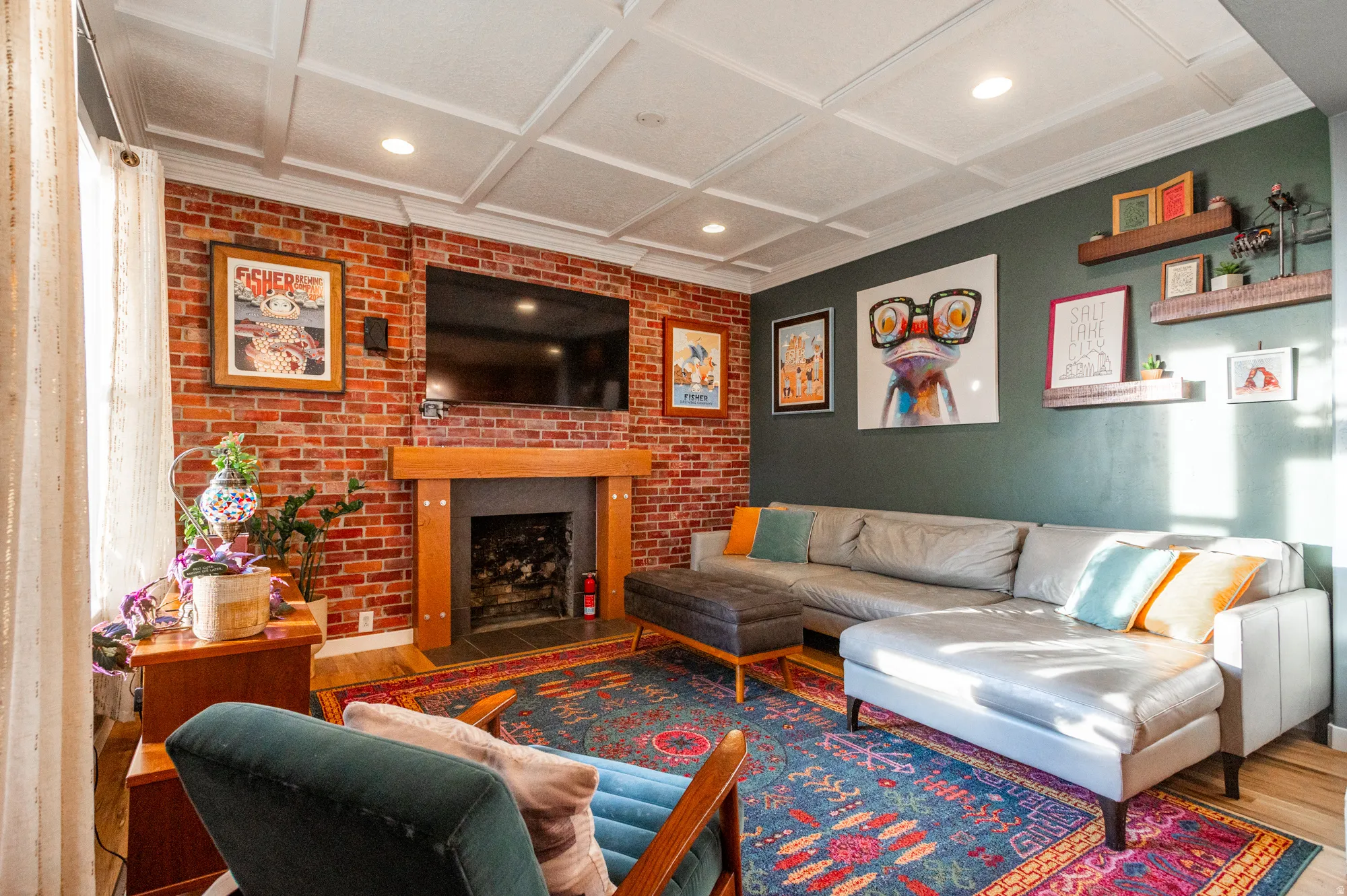 Living area featuring a coffered ceiling, exposed brick wall with a fireplace, and recessed lighting