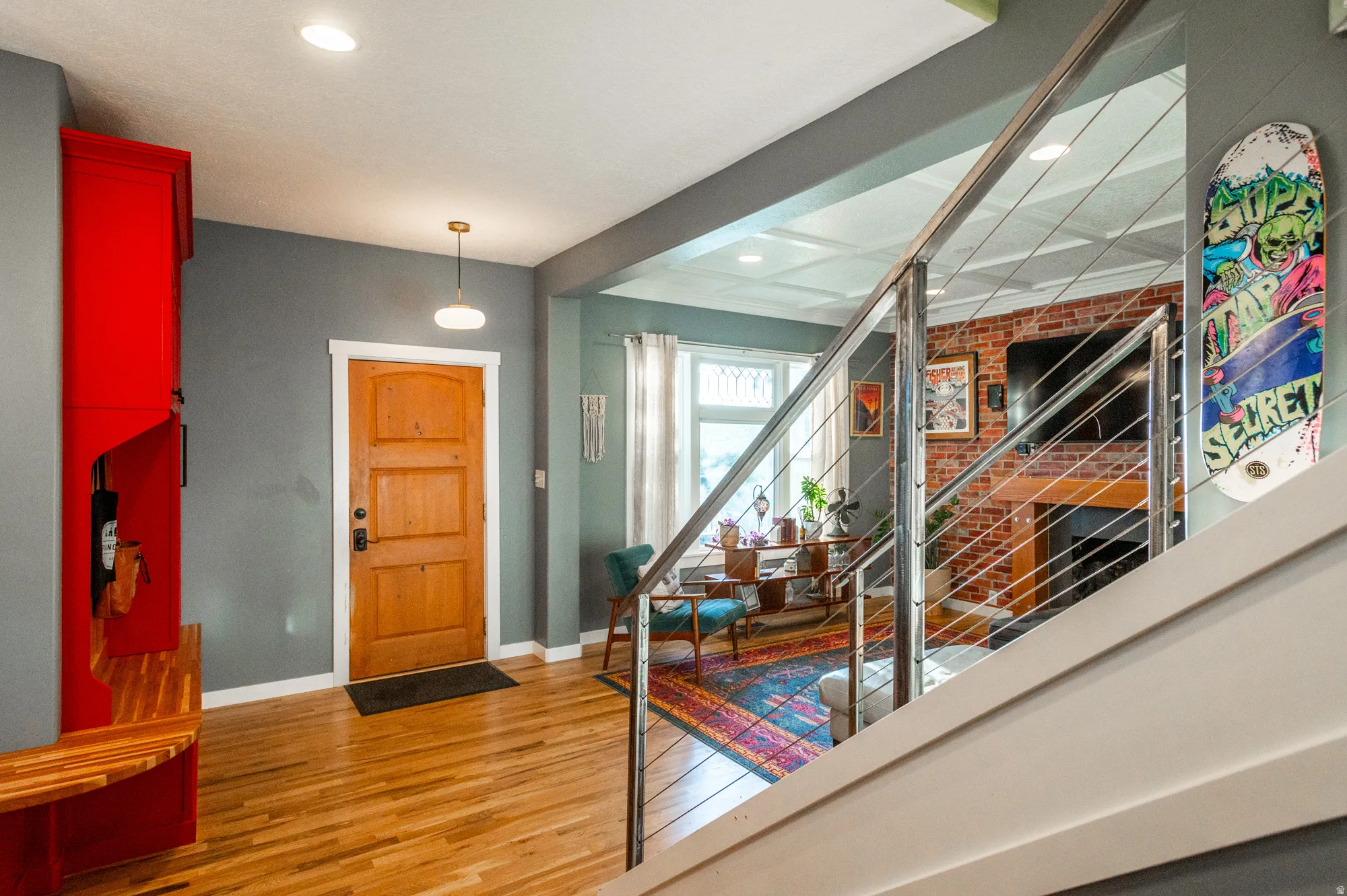 Hardwood flooring throughout the entry area, featuring a natural wood front door with a dark hardware set