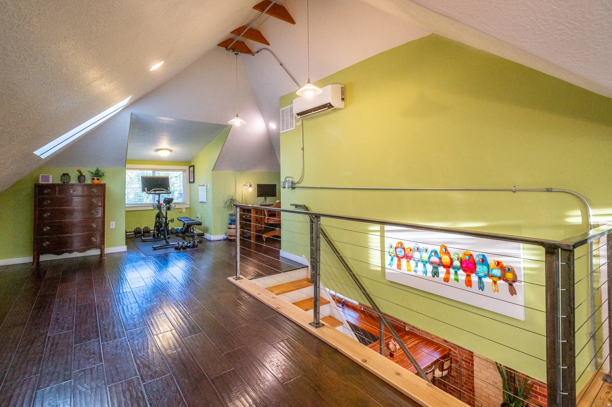 Open loft space featuring wood-finish flooring and a cable railing system