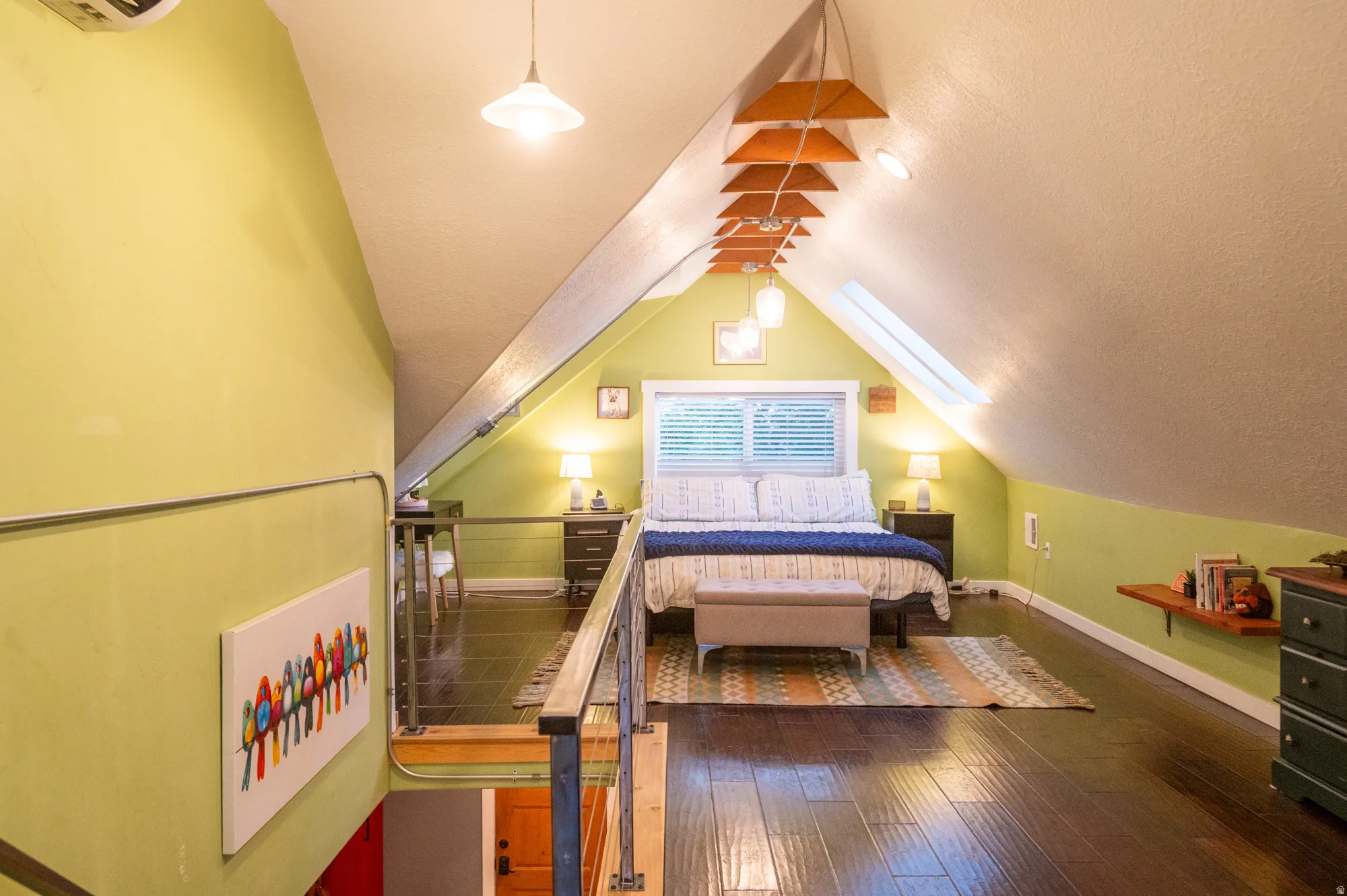 Loft bedroom featuring wood-finish flooring, an angled ceiling, and a skylight