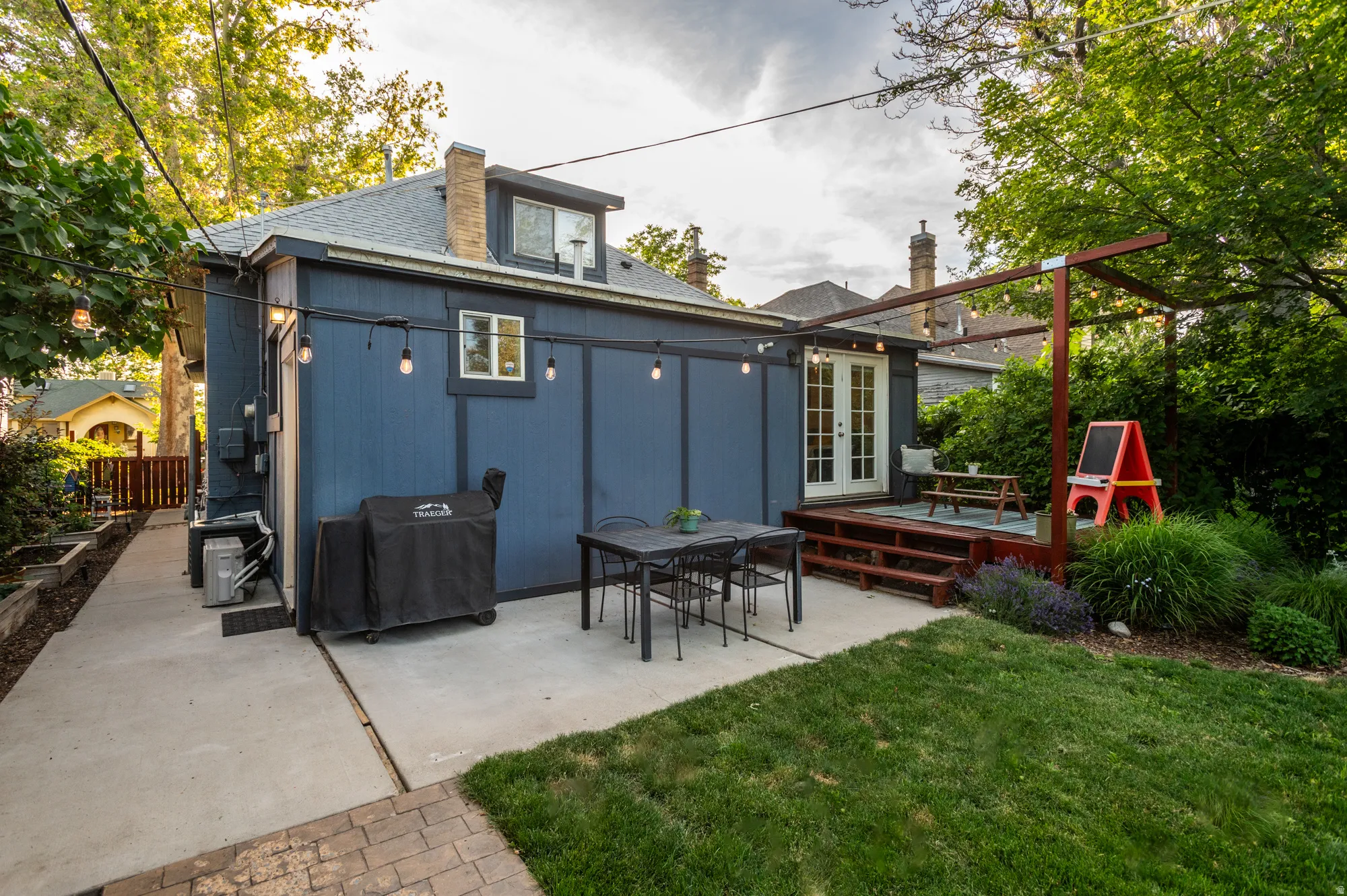 Rear exterior featuring a blue facade, white French doors, and a wood-toned deck with steps