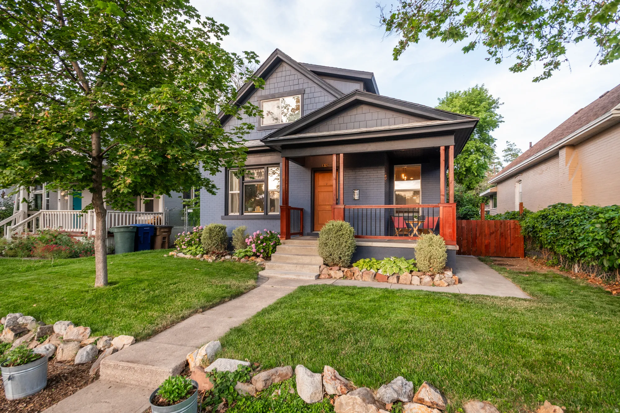 Craftsman-style home featuring a covered front porch with dark trim and reddish-brown railings