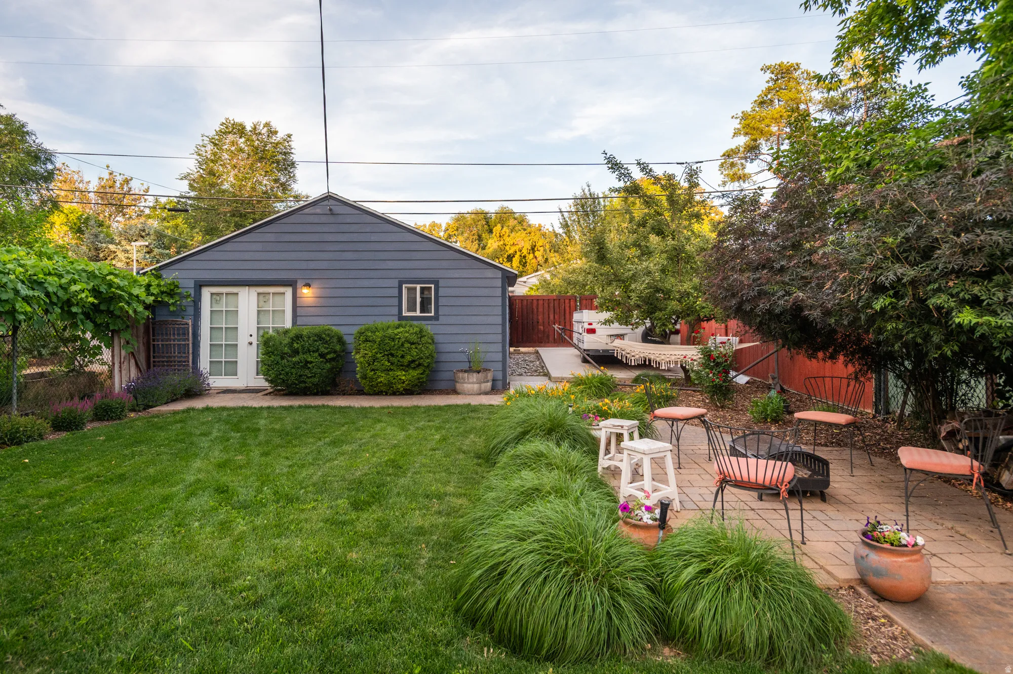 Expansive backyard featuring a manicured lawn and mature trees