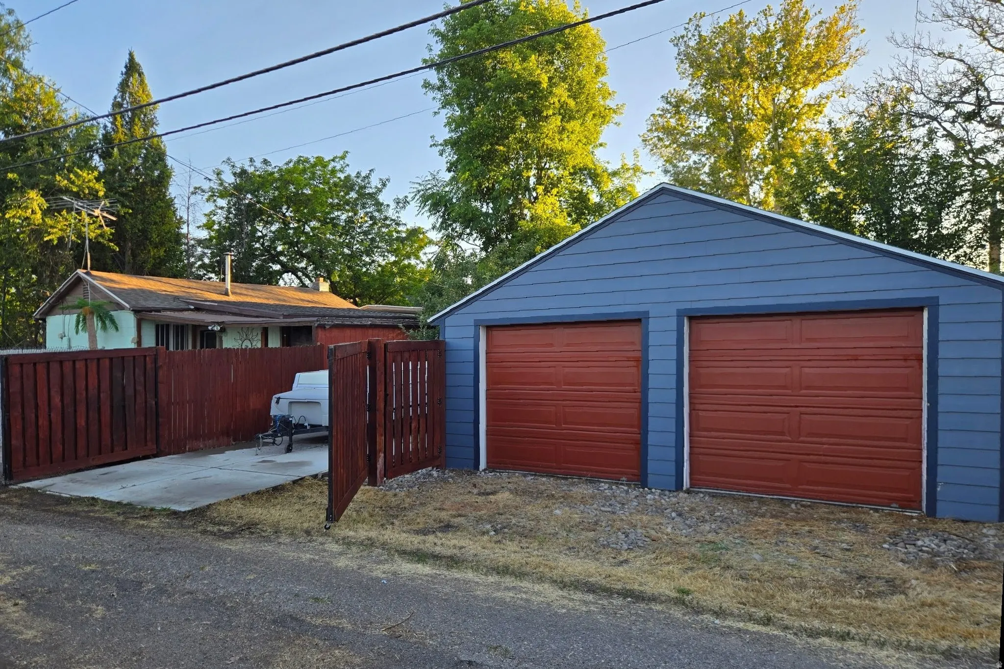 Detached two-car garage with blue siding and two red garage doors