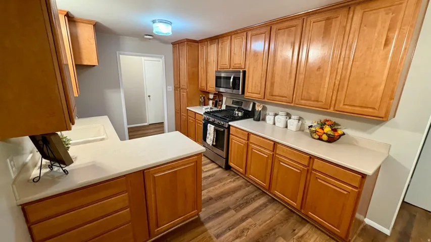 Kitchen View 1 - Lots of cabinets, solid surface countertops, and stainless steel appliances including a gas range and microwave