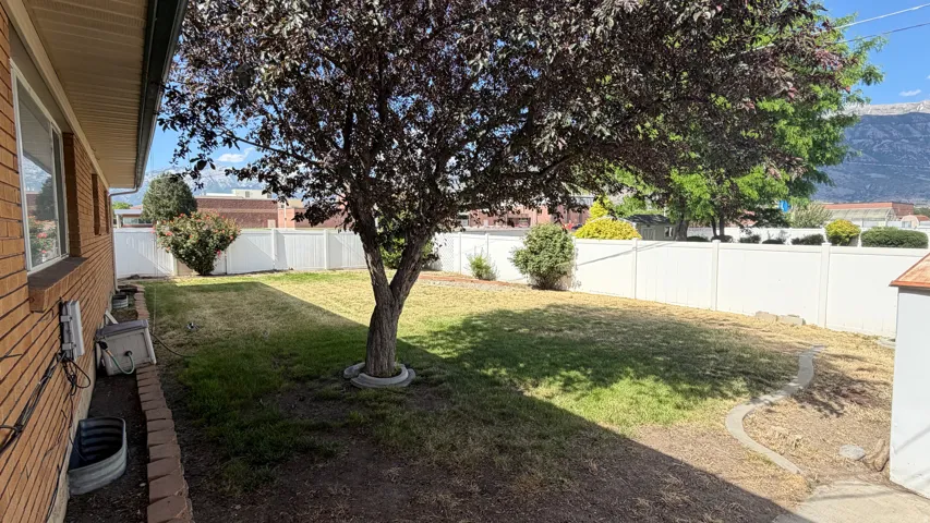 Spacious backyard enclosed by white vinyl fencing