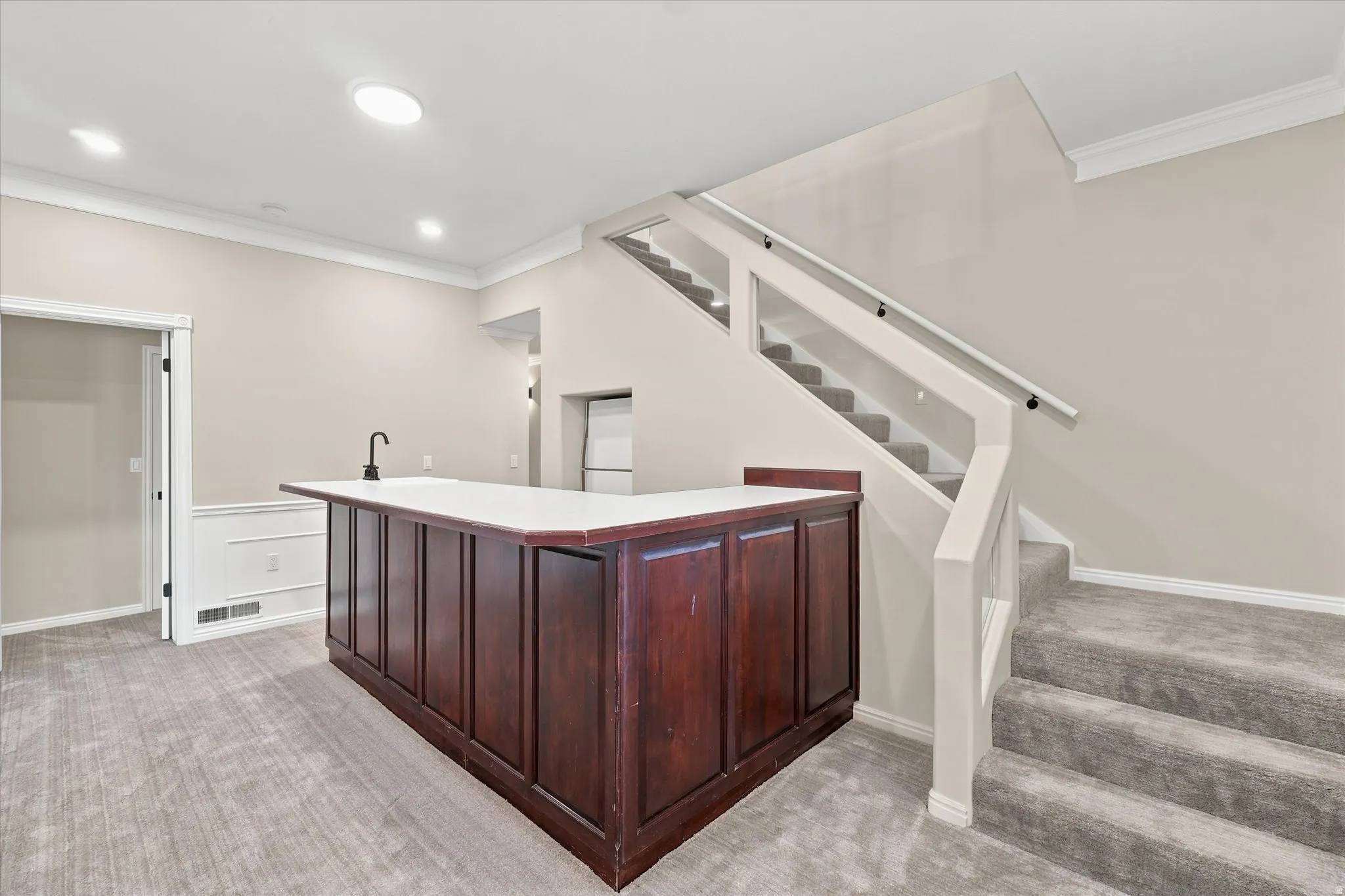 Custom built-in bar with white countertop and integrated sink with matte black faucet