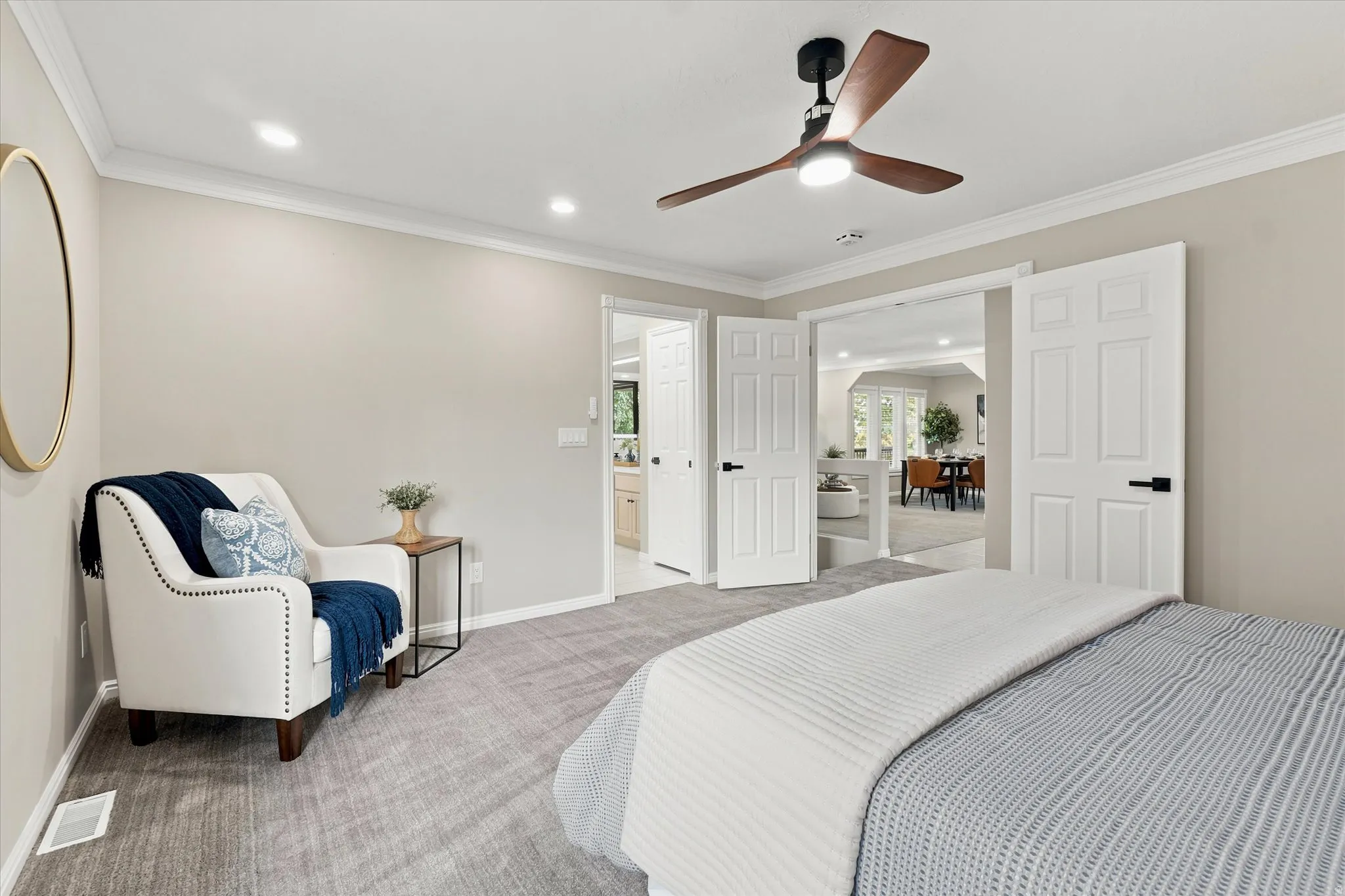 Spacious bedroom with light gray wall paint, recessed lighting, and a contemporary ceiling fan