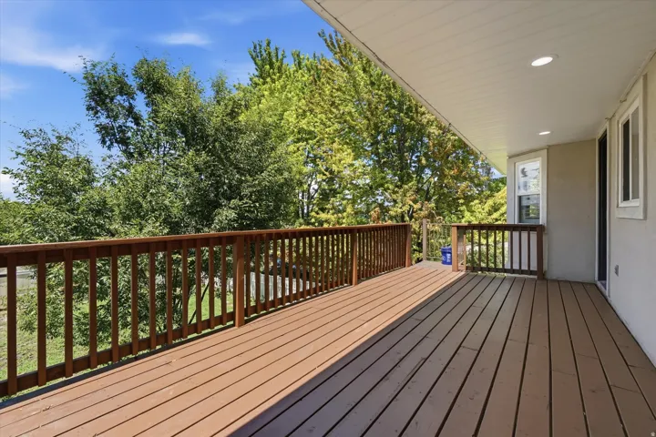 Expansive wood-finish deck with a wood railing system, offering an open-air extension of the living space