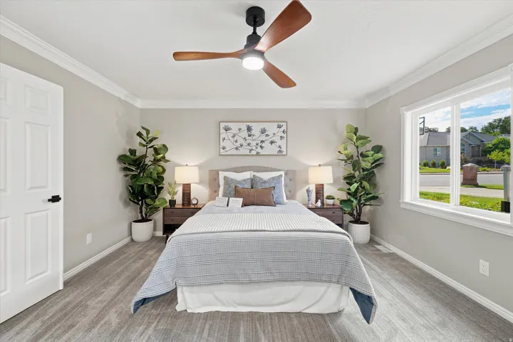 Bedroom featuring wood-finish flooring, a contemporary ceiling fan, and crown molding