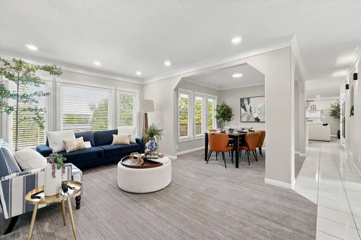 Spacious common area featuring recessed lighting, extensive crown molding, large window banks, and an arched entryway