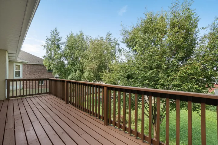 Spacious outdoor deck featuring wood-finish flooring and railing
