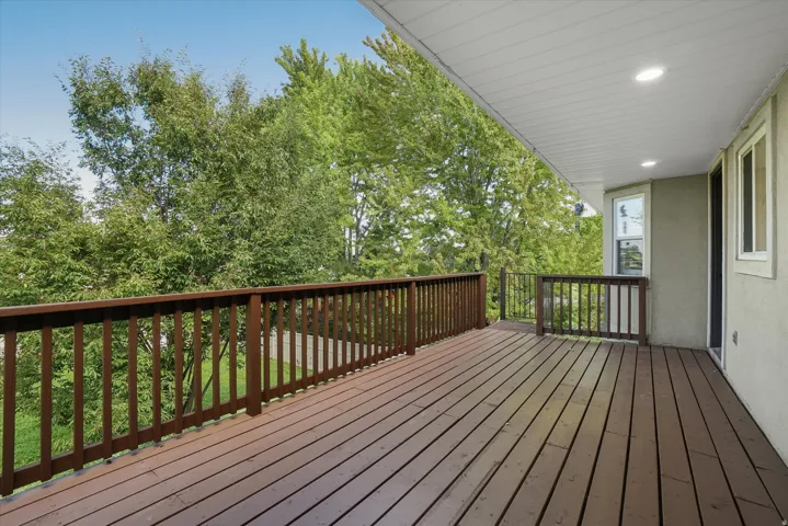 Spacious outdoor deck featuring wood-finish decking and dark wood railings