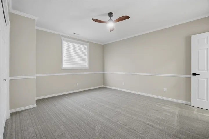 Neutral-toned walls featuring white chair rail molding and baseboards