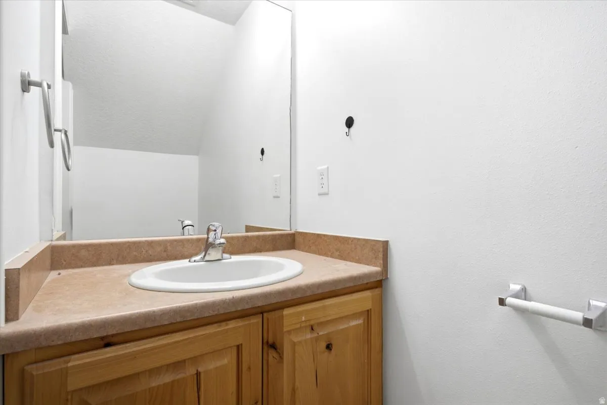 Bathroom vanity with wood cabinetry and a laminate countertop