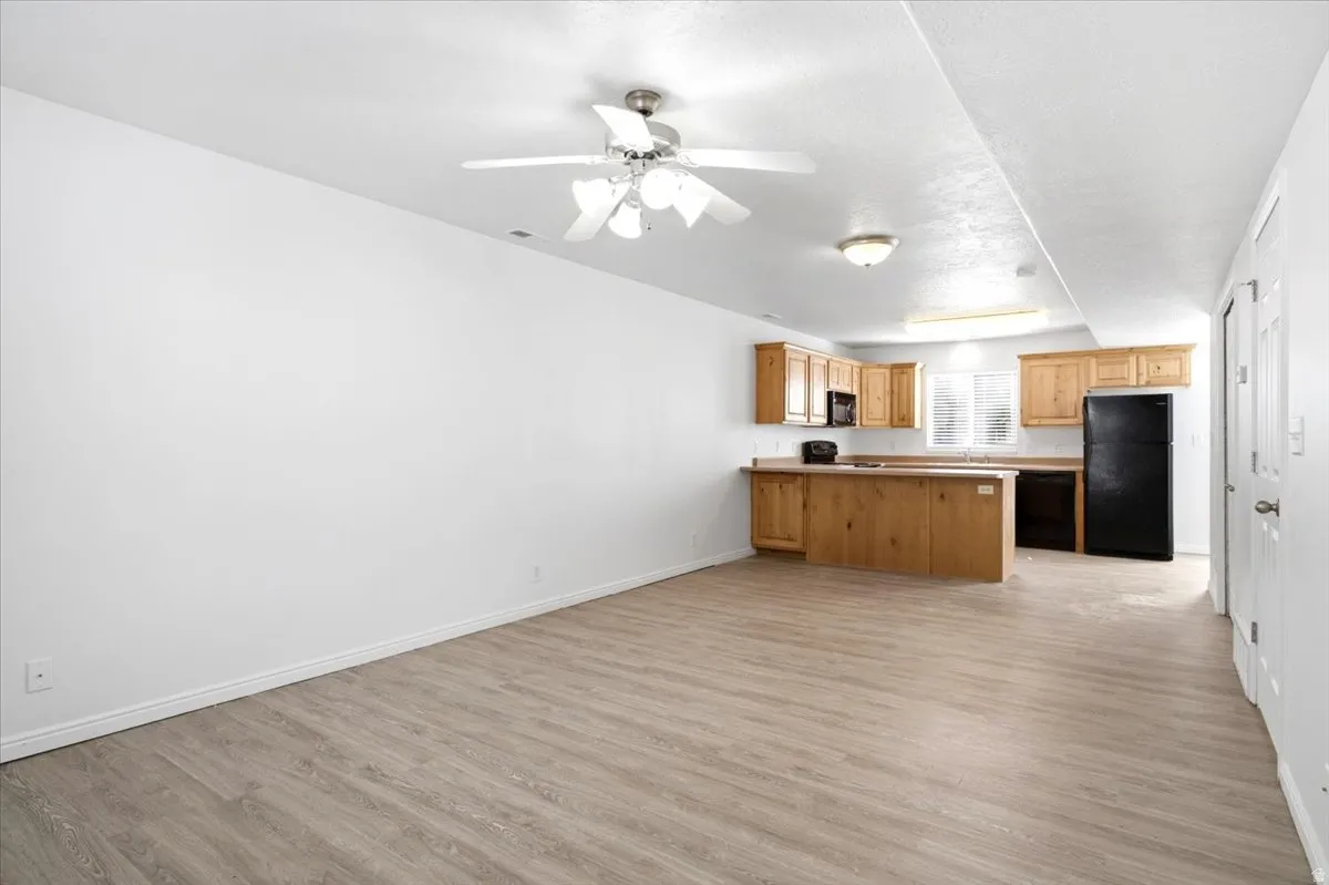 Open-concept living area featuring wood-finish flooring, a ceiling fan, and recessed lighting