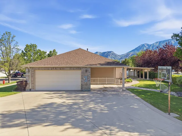 Single-story residence featuring a two-car garage, stone and stucco exterior, and a covered porch