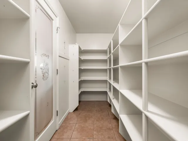 Walk-in pantry featuring extensive white shelving