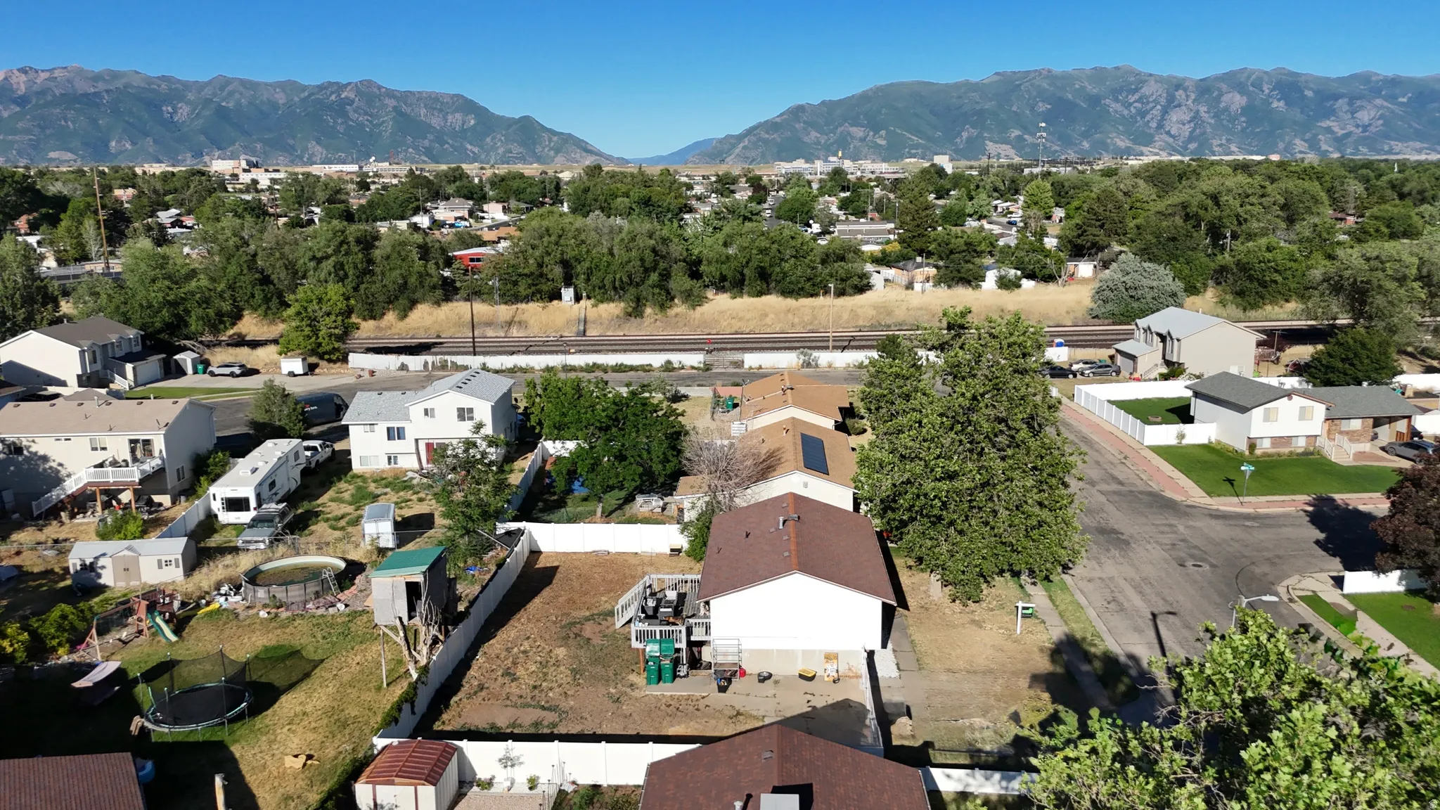 Residential neighborhood featuring mountain backdrops and a railroad corridor