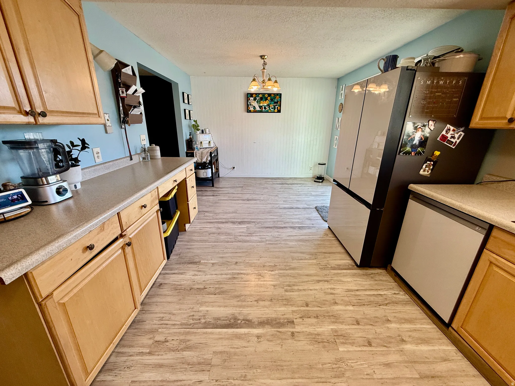 Kitchen featuring wood-finish flooring, light wood cabinetry, and neutral countertops