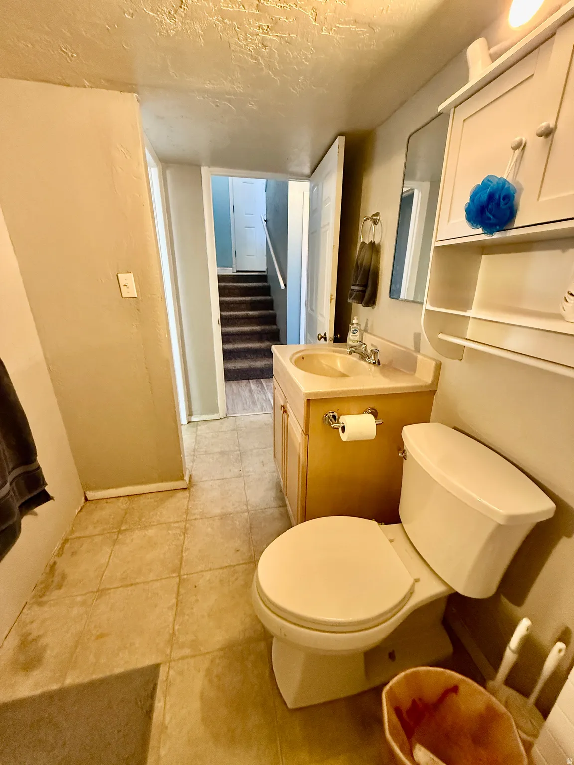 Bathroom featuring a vanity with a light wood-finish cabinet, integrated sink, and wall-mounted mirror