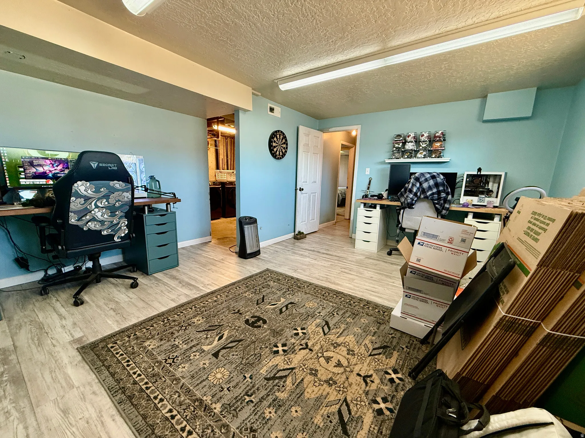 Spacious room featuring light blue walls and wood-finish flooring