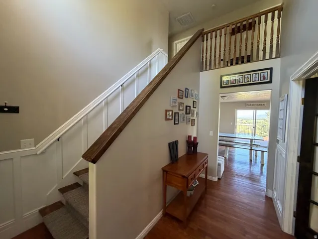 Staircase featuring wainscoting and a wood-finish handrail