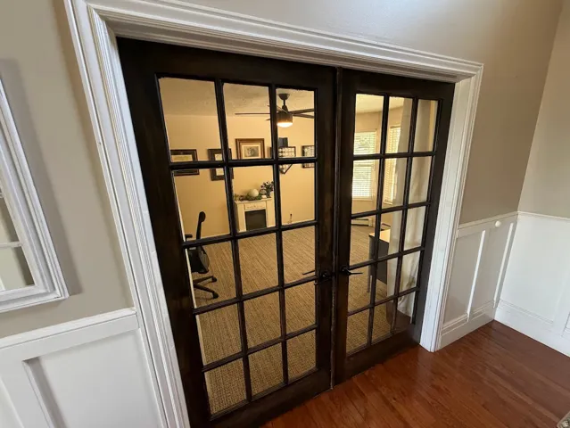 Rich wood-finish flooring complements the wainscoting and crown molding
