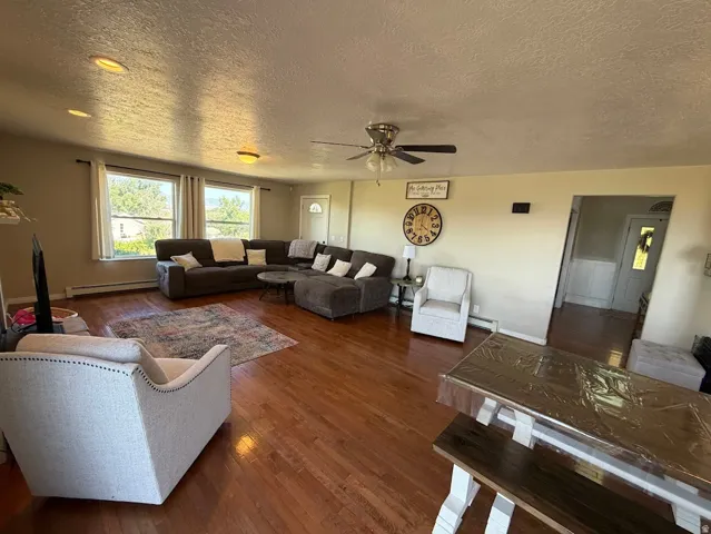 Spacious living area featuring wood-finish flooring, recessed lighting, and a ceiling fan