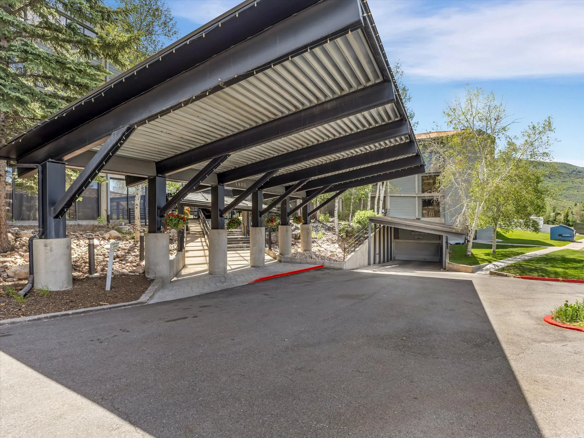 Covered entryway with robust structural beams and concrete columns