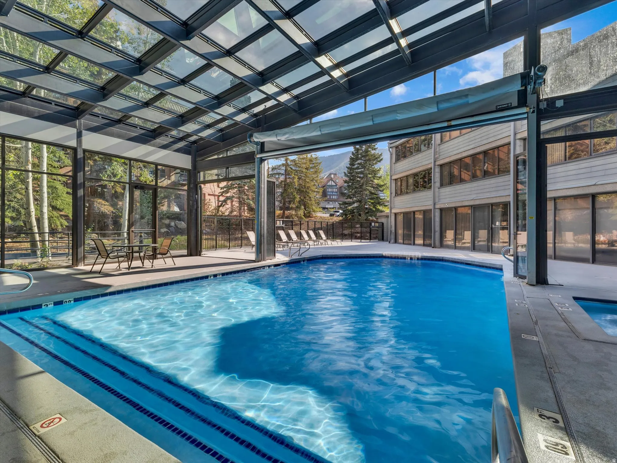Indoor/outdoor pool with a retractable glass enclosure