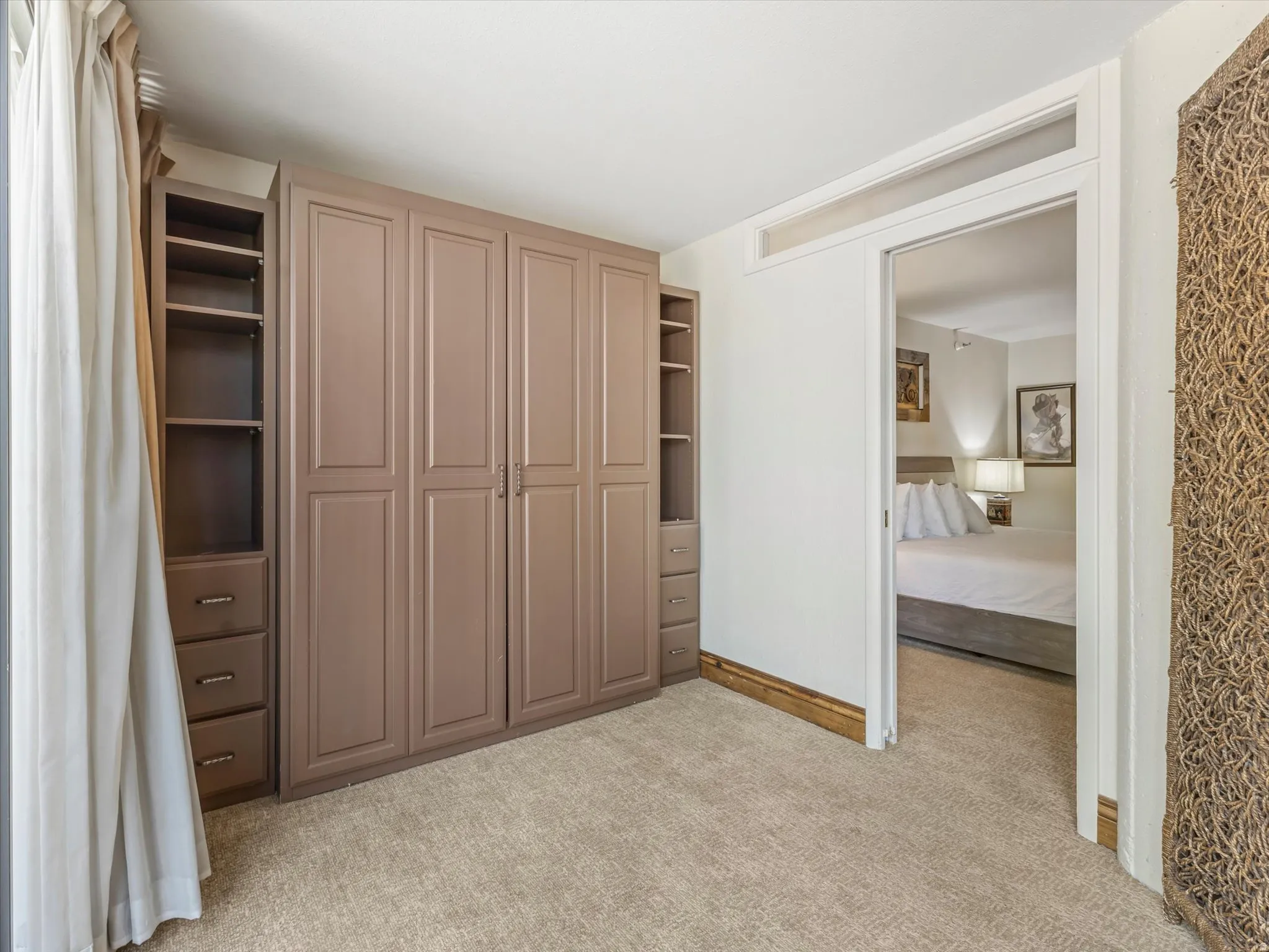 Built-in wardrobe system with panel doors, open shelving, and drawer storage