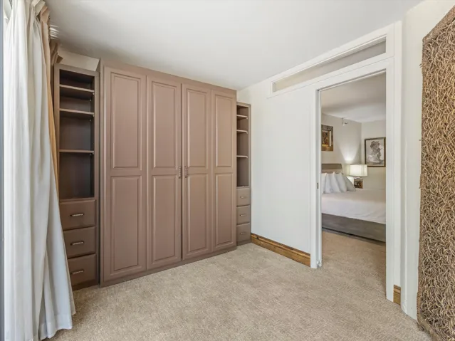 Built-in wardrobe system with panel doors, open shelving, and drawer storage