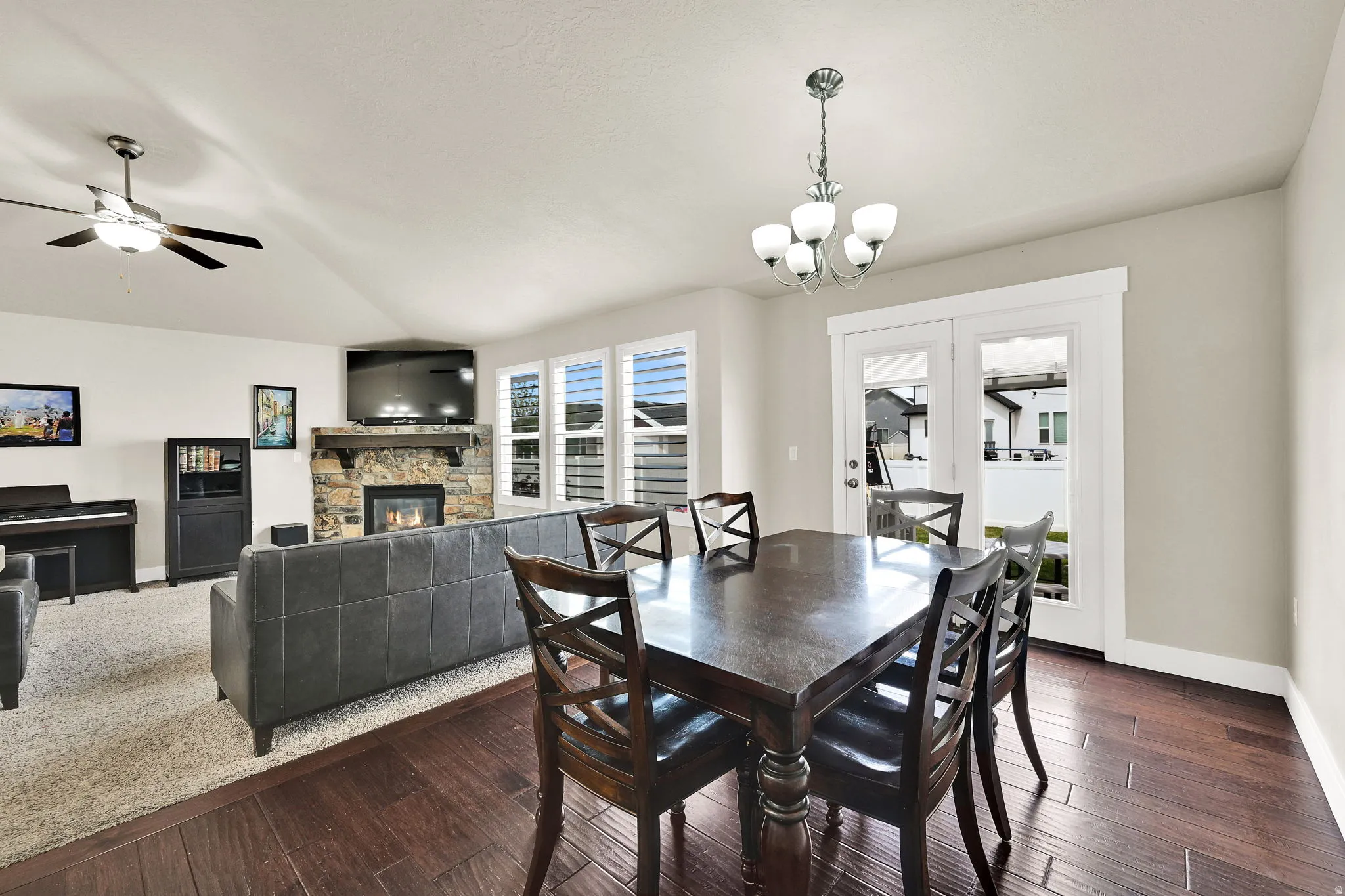 Open concept dining area featuring wood-finish flooring, a contemporary chandelier, and French doors