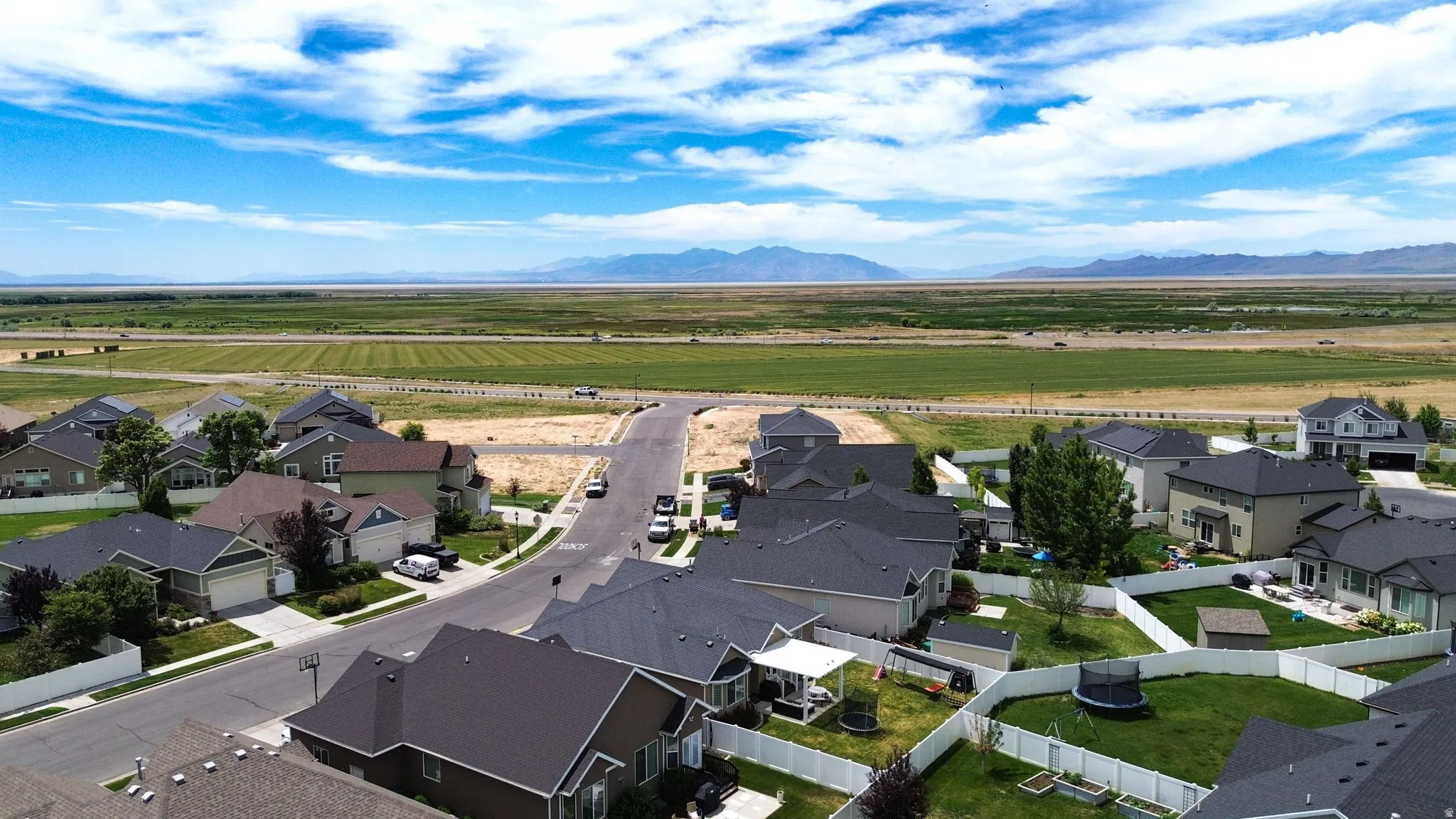 Aerial perspective of a residential neighborhood featuring homes with dark shingle roofs and light-colored siding