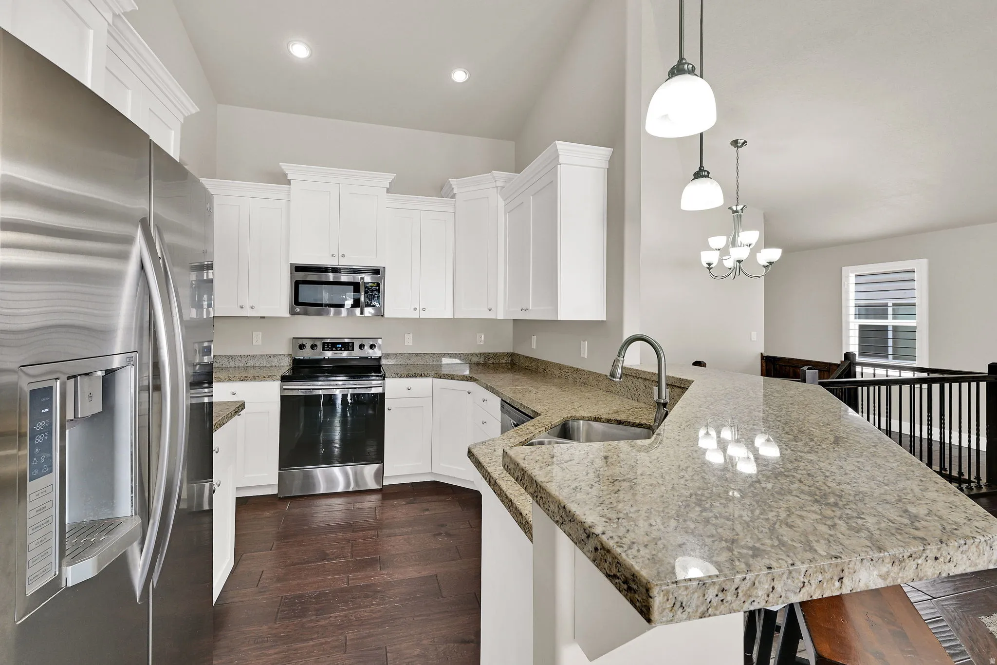 Kitchen featuring white cabinetry, stainless steel appliances, speckled stone countertops, and wood-finish flooring