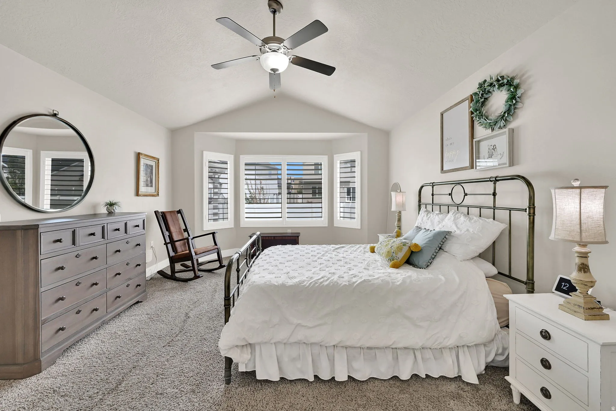 Bedroom featuring a vaulted ceiling, ceiling fan with integrated lighting, and carpet flooring