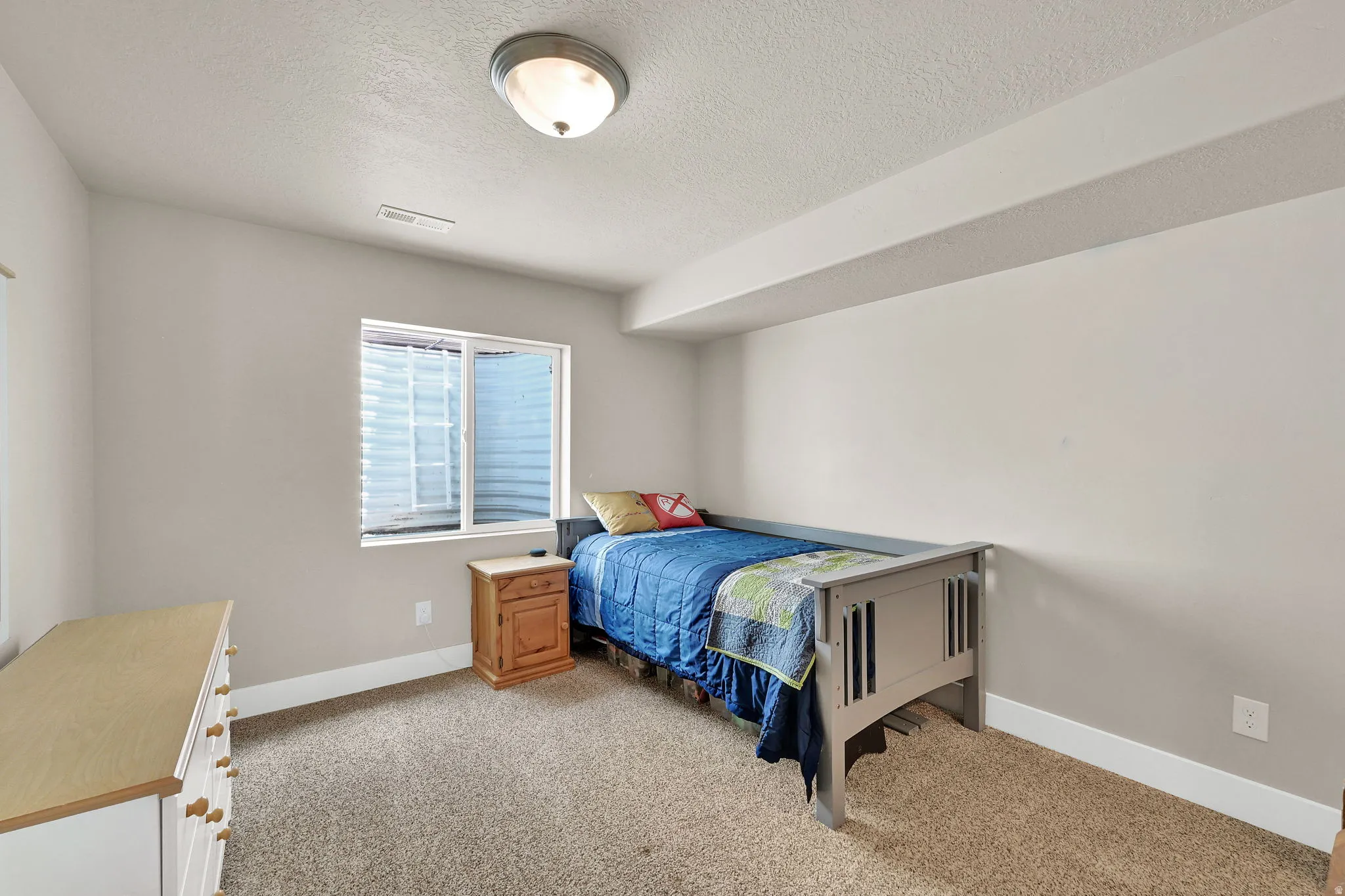 Carpeted room with neutral wall paint and a white ceiling